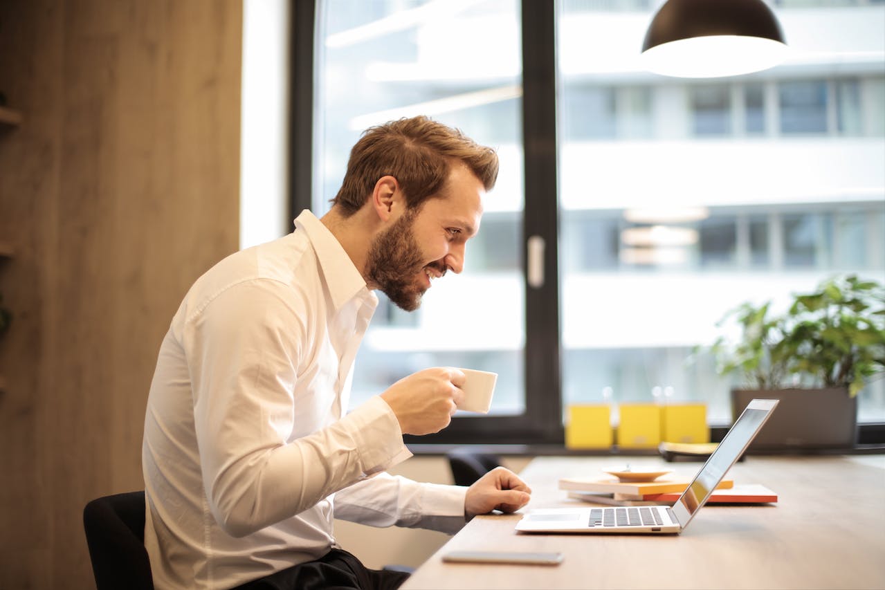 Man smiling at his laptop